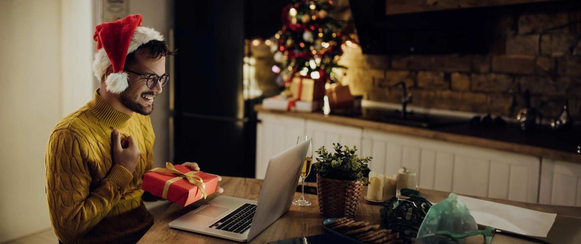 Un homme sur son ordinateur avec un chapeau de noel