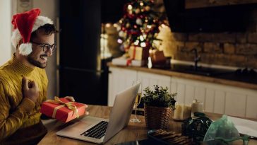 Un homme sur son ordinateur avec un chapeau de noel